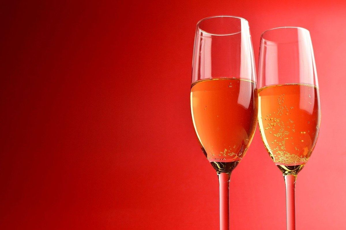 Bulles dorées sur fond rouge : l'accord parfait pour un repas festif avec du champagne.