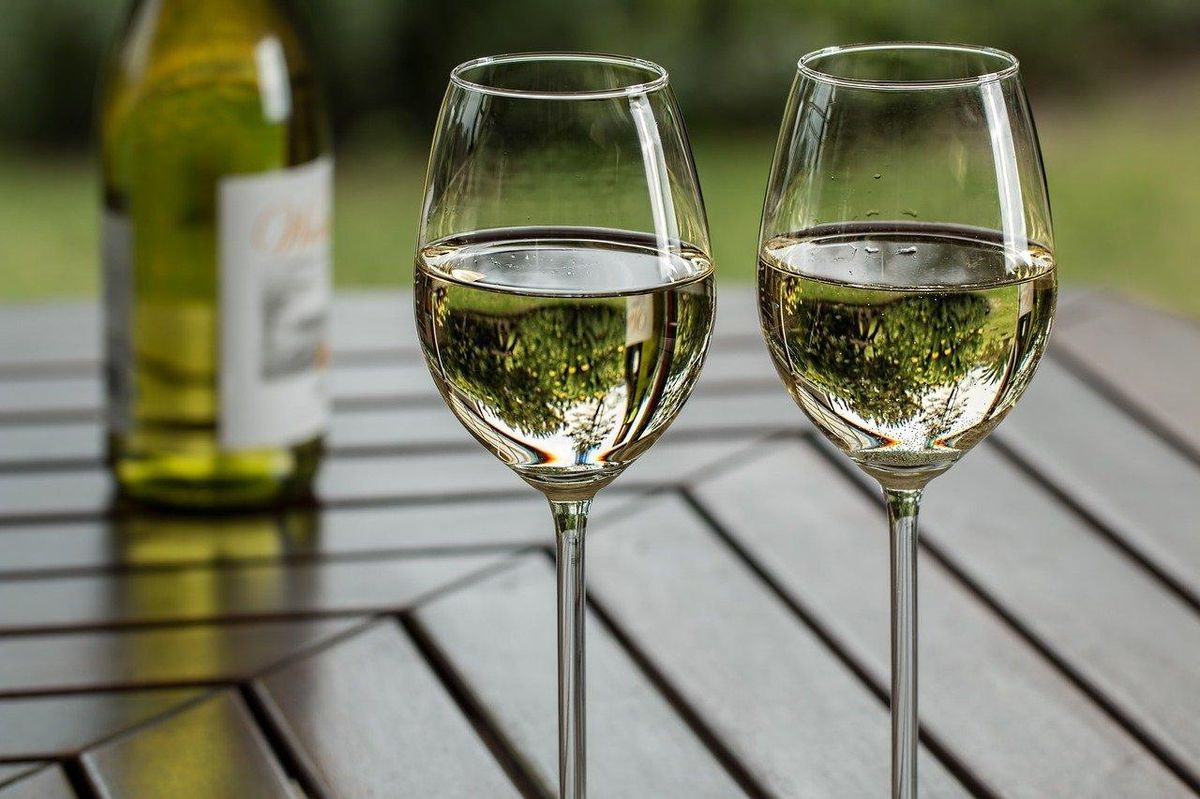 Deux verres de vin blanc sur table; éviter l'oxygène est clé pour le conserver.
