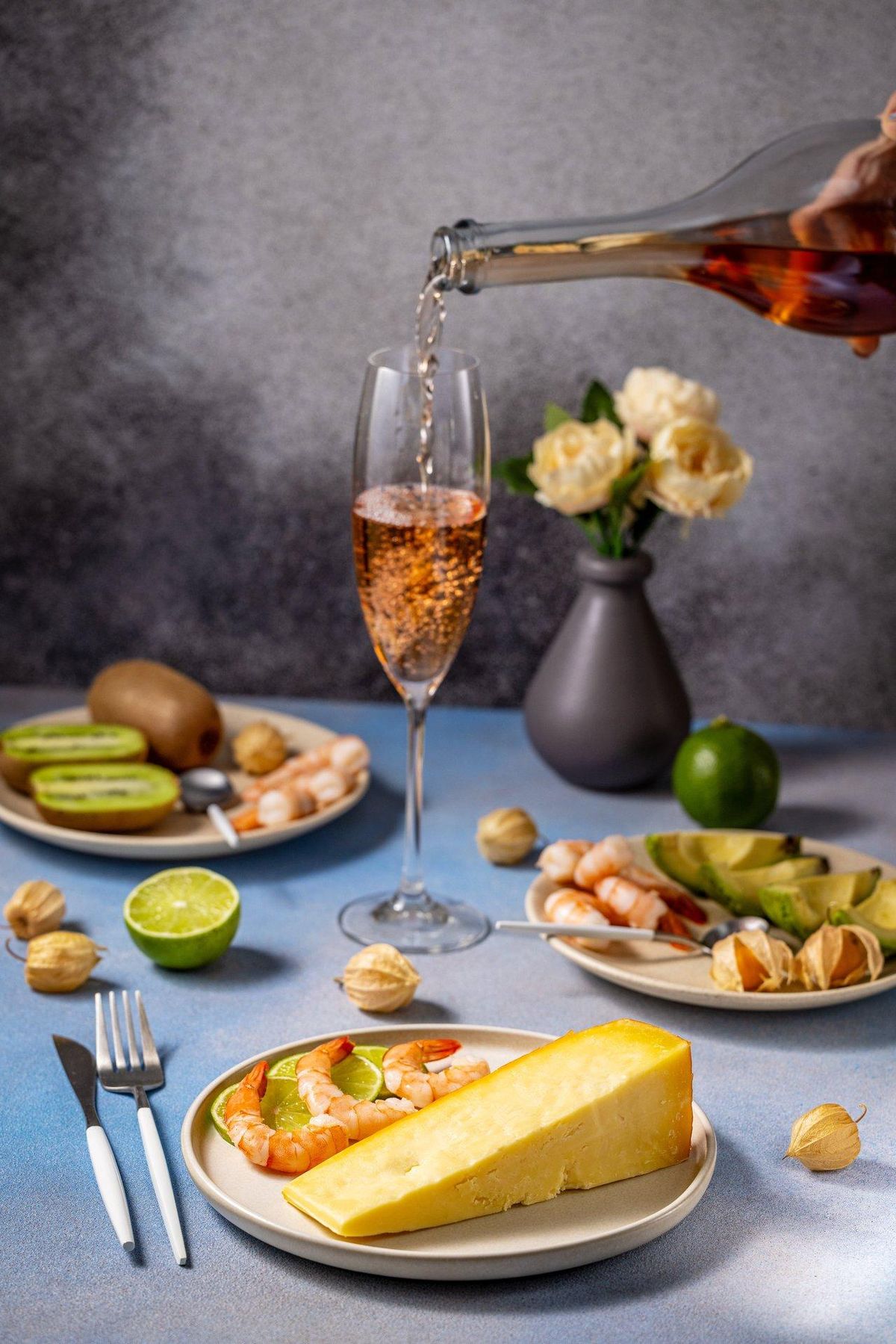 Verre de rosé wine servi avec fromage, fruits et crustacés, idéale pour le printemps 2025.