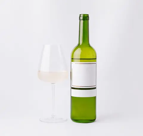 Bouteille et verre de vin blanc sur fond épuré, illustrant l’acidité et la dégustation.