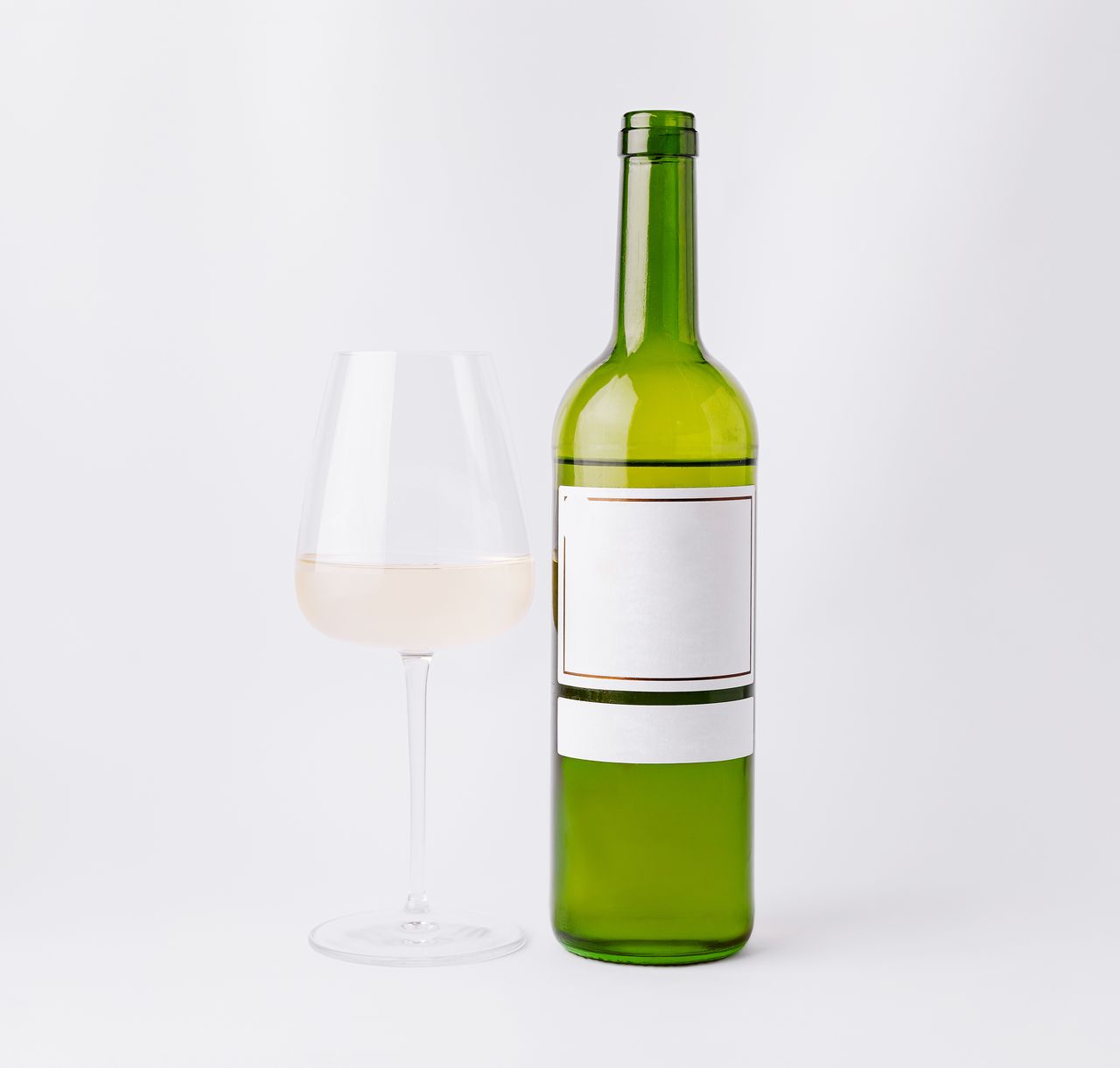 Bouteille et verre de vin blanc sur fond épuré, illustrant l’acidité et la dégustation.